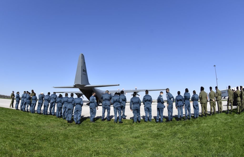 Cadets de l’Escadron 80 K-W Spitfire en formation devant un avion militaire